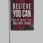 A garden flag with the quote believe you can and your halfway there adding a personal and motivational touch to the outdoor space