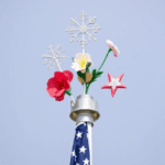 A seasonal flagpole featuring interchangeable toppers like snowflakes, flowers, and patriotic stars. Seasonal Flags and House Flags."